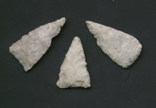 Photo of three simple flaked chert arrow points.